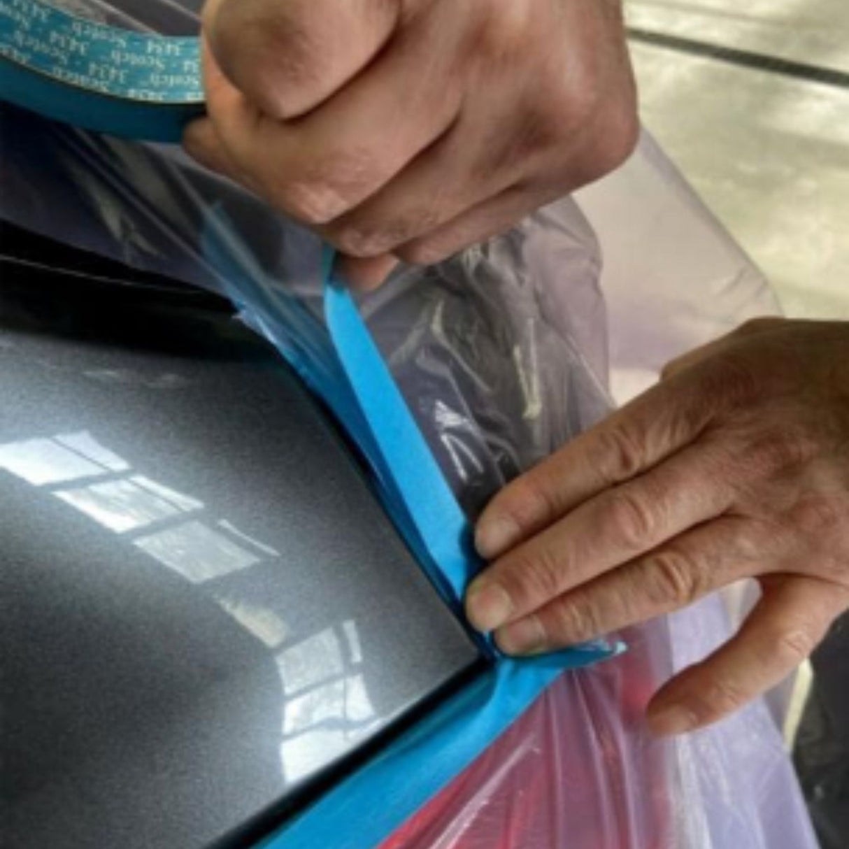 Person applying blue masking to surface, Ultrimax