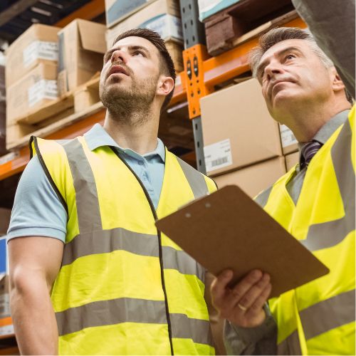 two people in warehouse wearing high visibility vests